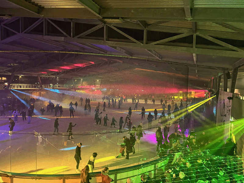 Volle Eisfläche an der Eisdisco im Schüwo Park Wohlen unter violetter Lichtshow